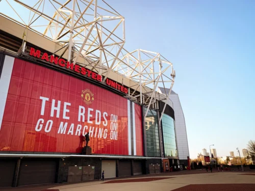 Picture of Old Trafford with a "The Reds Go Marching On" sign