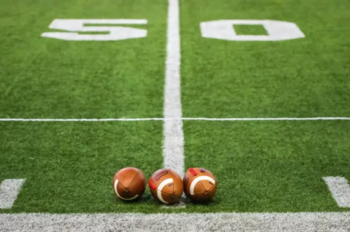 Three footballs at the 50-yard line