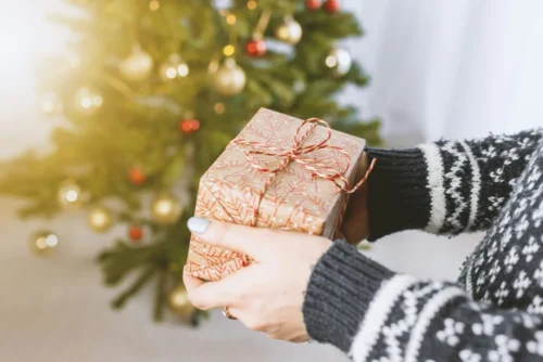 Person holding a wrapped Christmas gift