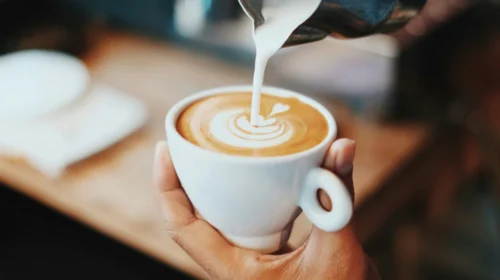 Milk being poured into a latte coffee