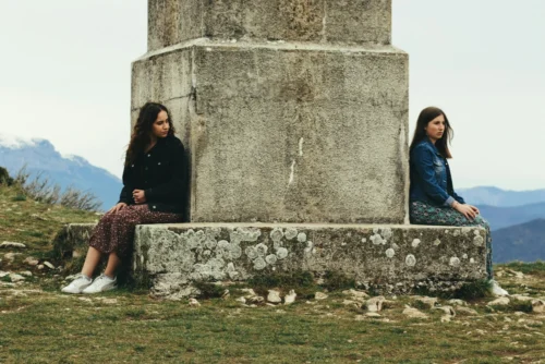Two people sitting by a statue