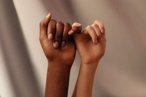 A couple holding by the pinkies